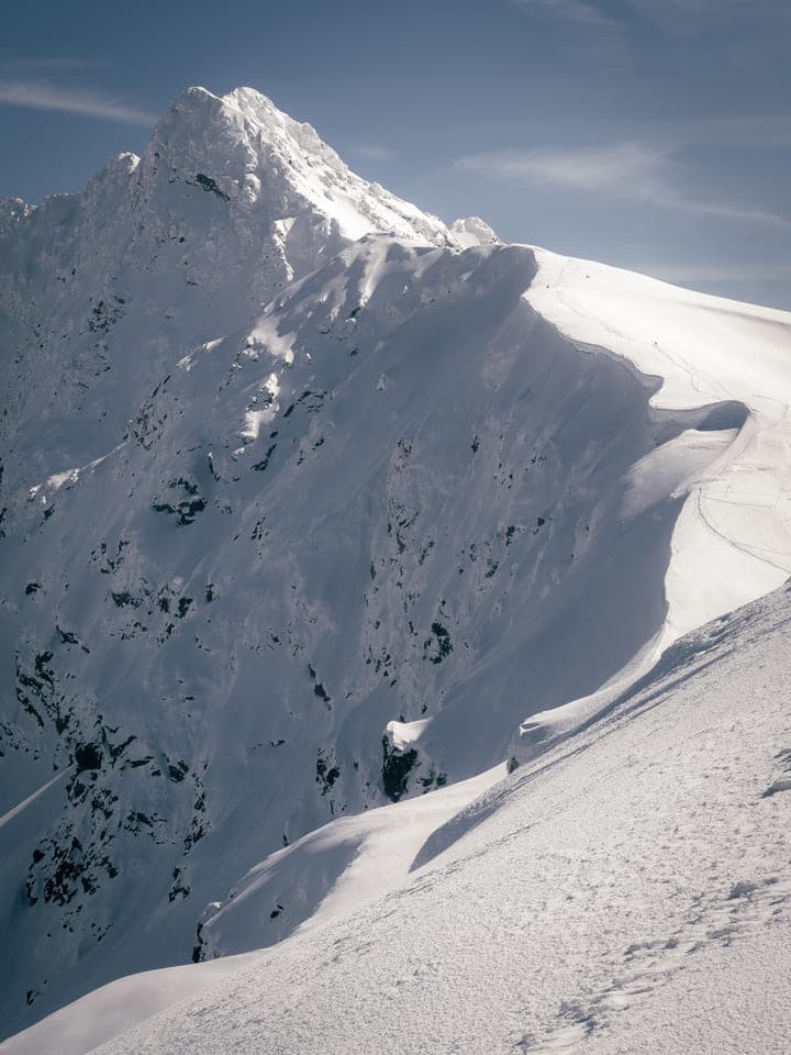 Snow-covered mountain ridge under a clear winter sky